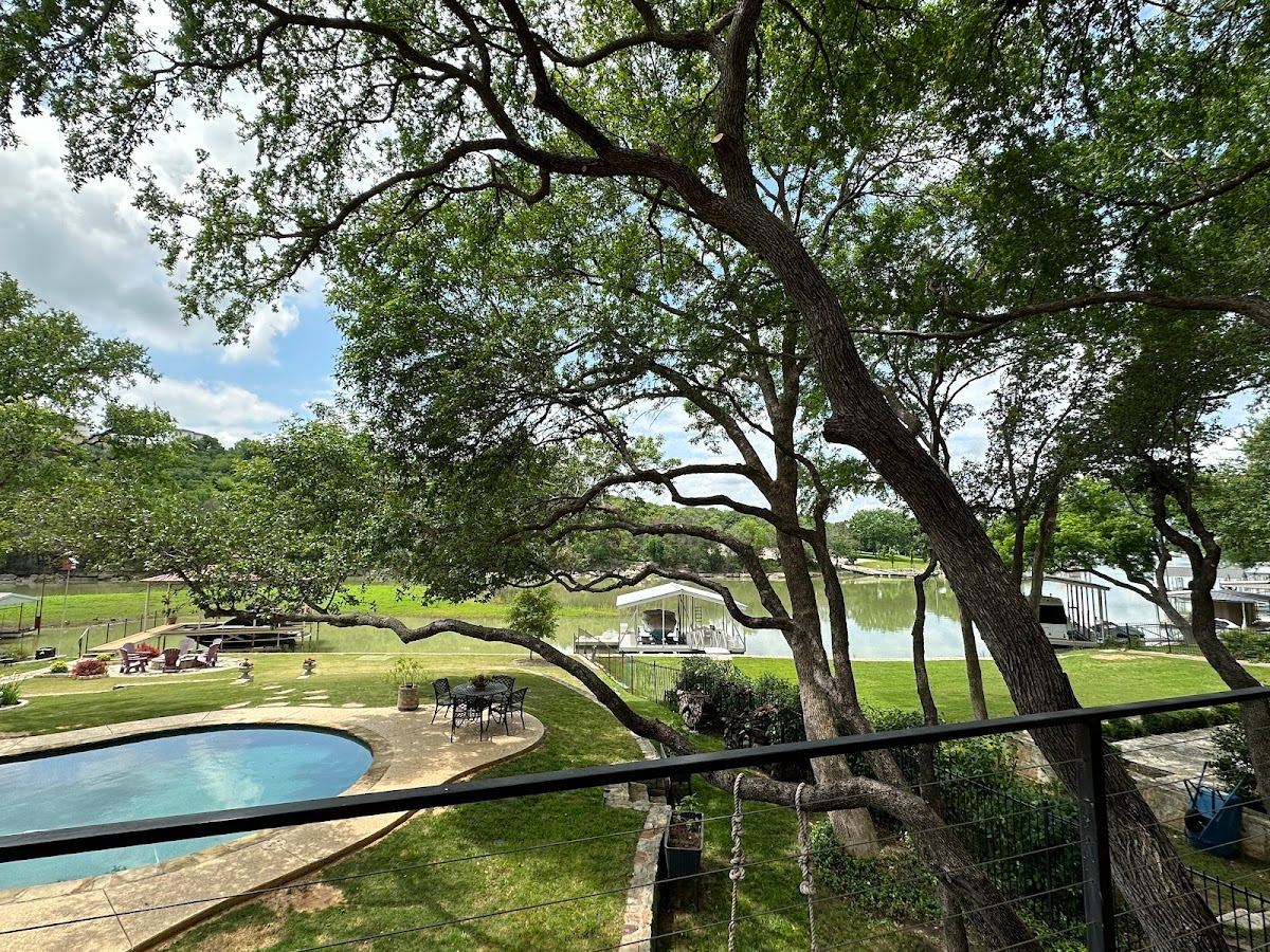 Sprawling live oak shading a lakeside pool and patio at a Texas Hill Country property